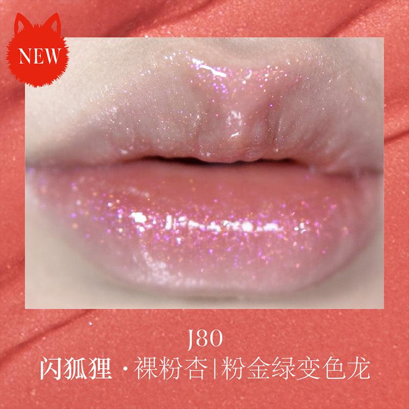 Close-up of lips wearing Girlcult The Classic of Bizarre Tales Lip Glaze in J80, featuring a nude pink gloss with pink-gold-green shifting shimmer.