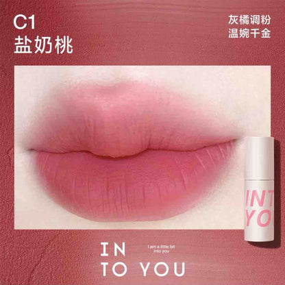 INTO YOU Airy Lip &amp; Cheek Mud in C1, offering a delicate peachy-pink tone for a soft, feminine touch