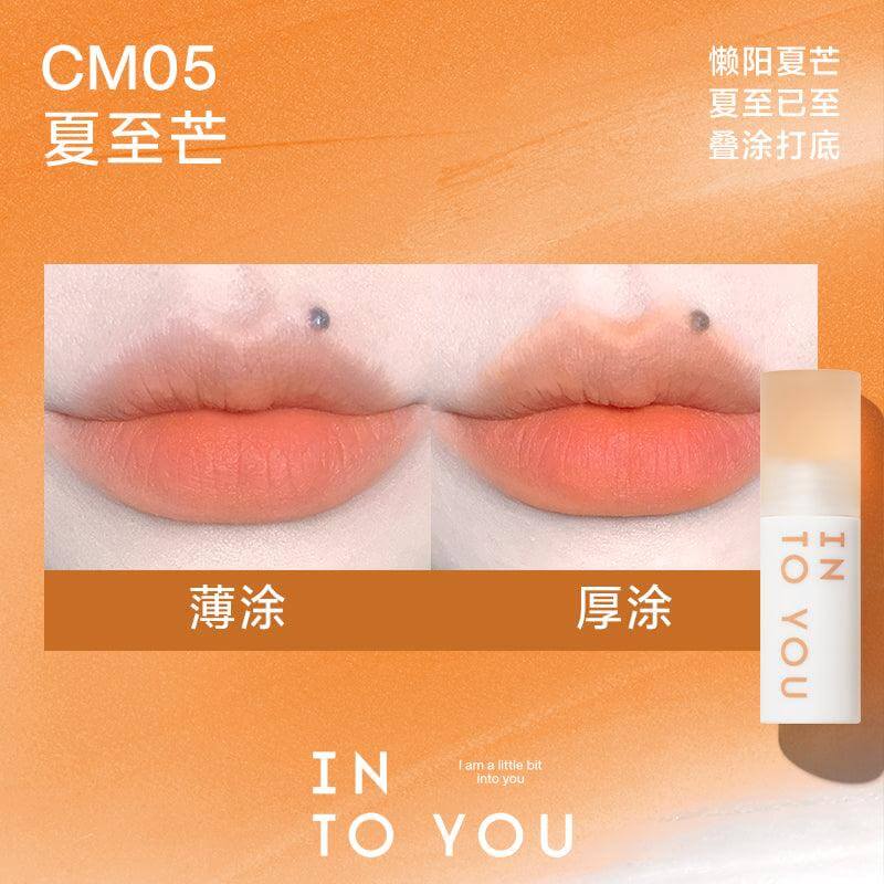 INTO YOU Cloudy Lip Mud in CM05, featuring a bright mango-orange shade, ideal for a bold and summery makeup look.