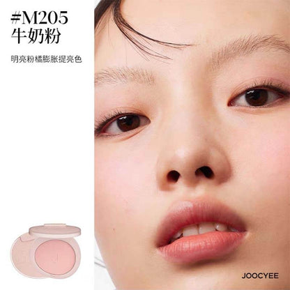 Close-up of a model wearing JOOCYEE New Loose Powder Matte Blusher in shade M205, a bright milky pink that highlights the cheeks with a soft, matte finish