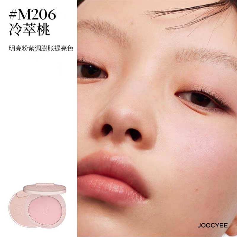 Application of JOOCYEE New Loose Powder Matte Blusher in shade M206, a cool mauve pink with a luminous matte finish, enhancing the model&