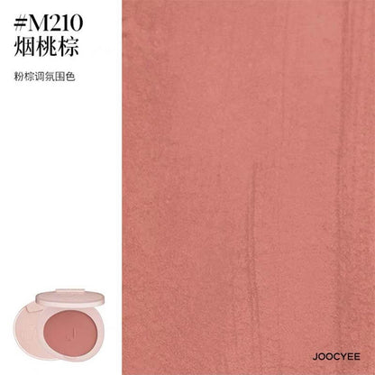 Close-up of JOOCYEE New Loose Powder Matte Blusher in shade M210, a soft peach tone that imparts a natural, matte glow to the skin.