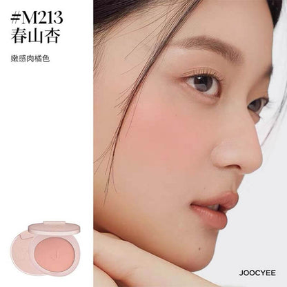 Profile view of a model with JOOCYEE New Loose Powder Matte Blusher in shade M213, a warm flesh orange color that delivers a soft, matte radiance